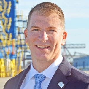 A professional headshot of Doug Vogt, Chief Operating Officer of North Carolina Ports. Container Cranes are in the background.